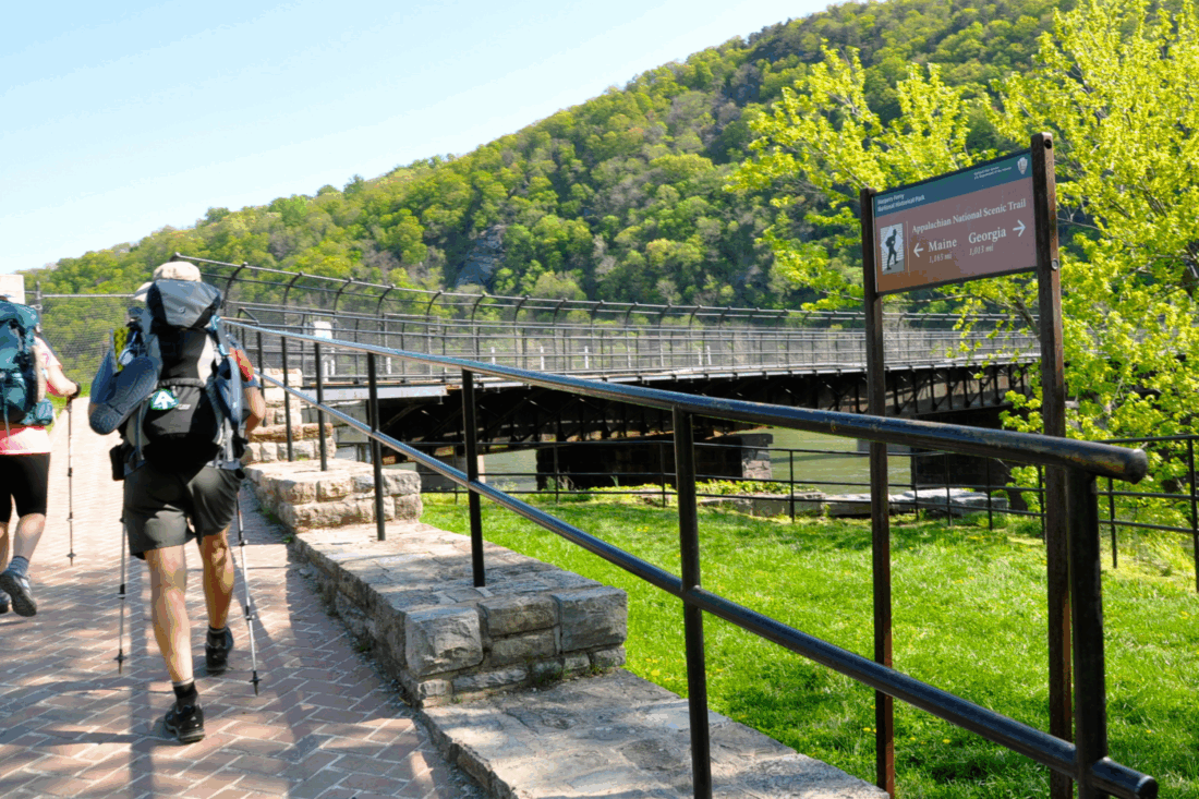 Two people hiking a trail with a brick path