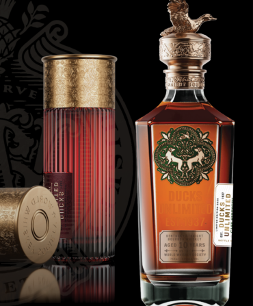 Two shotgun shell-shaped containers of whiskey and a bottle of bourbon