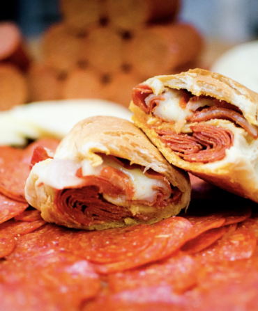 A pepperoni roll on a bed of pepperonis