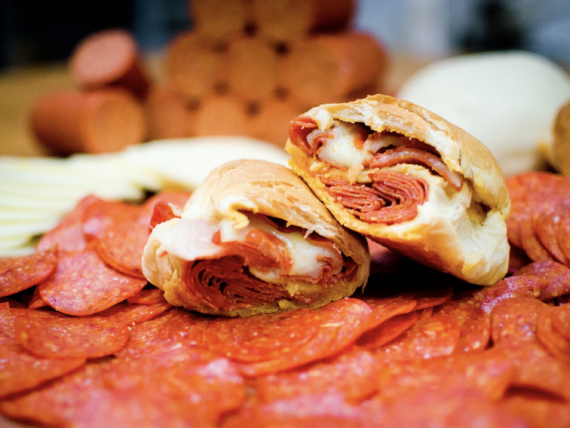 A pepperoni roll on a bed of pepperonis